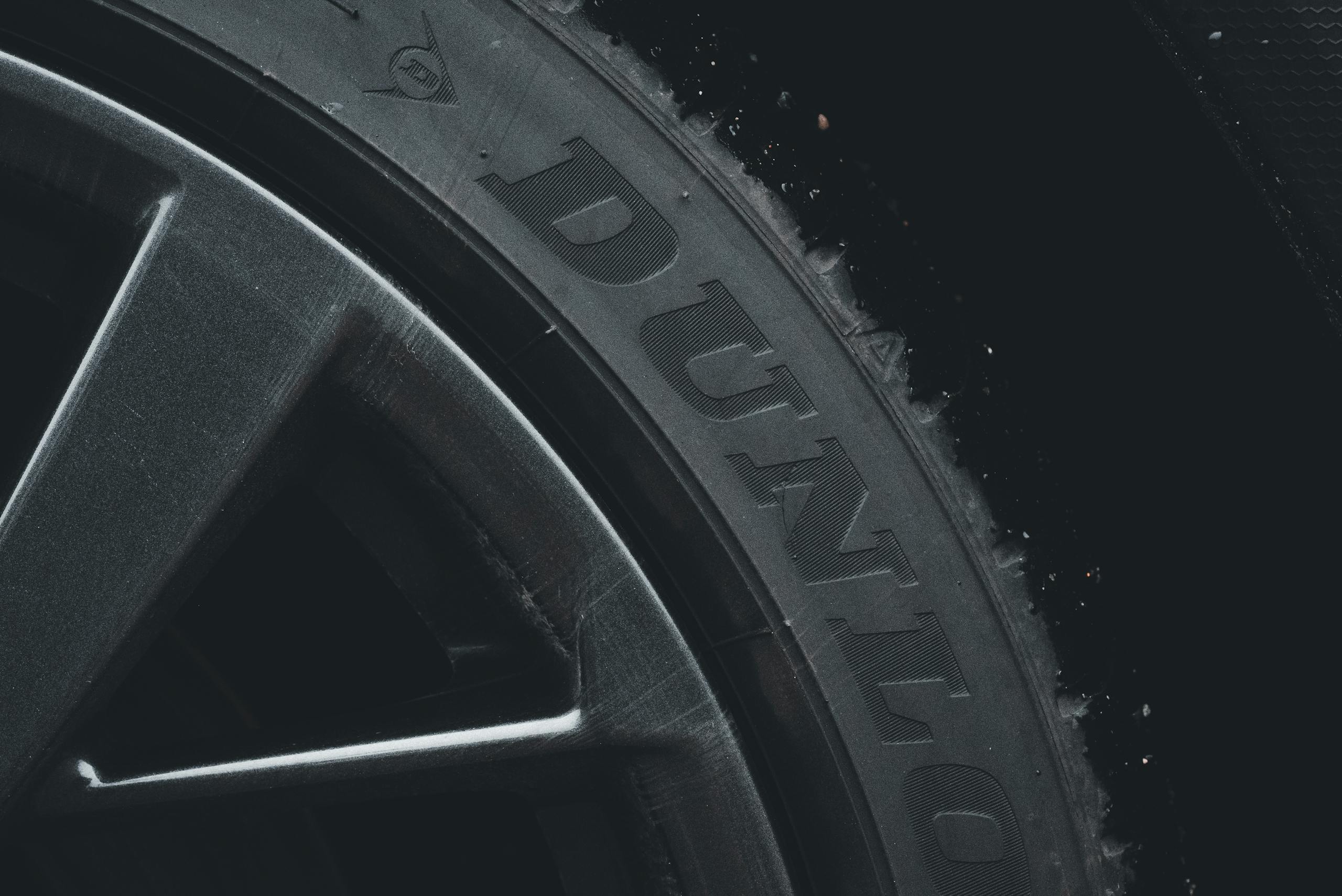 Detailed close-up of a Dunlop tire and rim showcasing its texture and brand text.