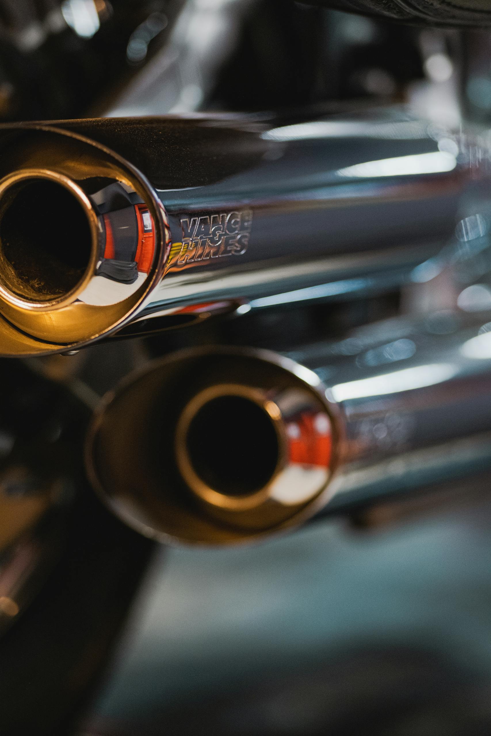 Detailed view of chrome motorcycle exhaust pipes with Vance & Hines branding.